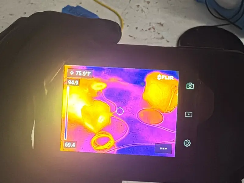 Thermal imaging camera checking for hidden moisture on a restoration job site before drying